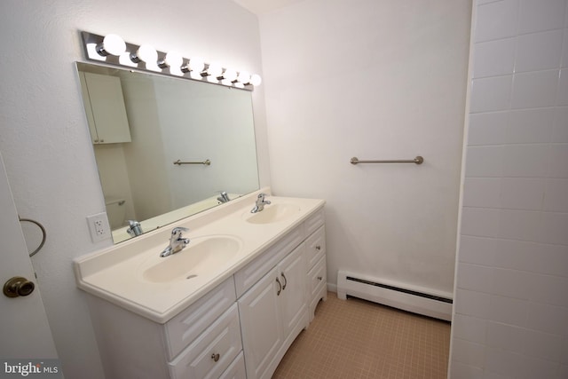 full bathroom featuring double vanity, baseboard heating, a sink, and tile patterned floors