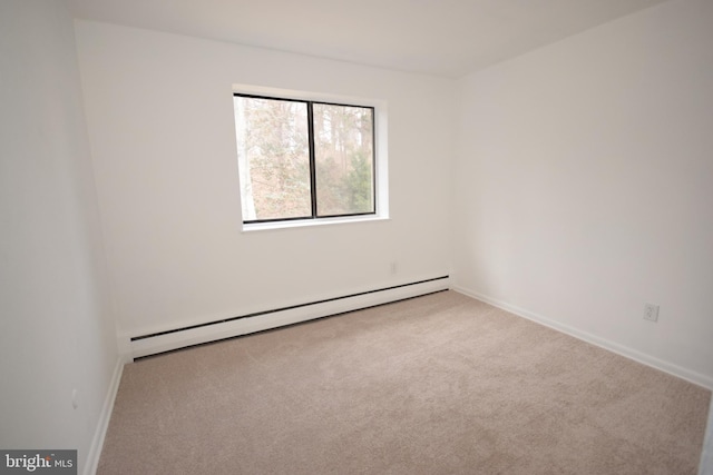 spare room with baseboards, a baseboard heating unit, and carpet flooring