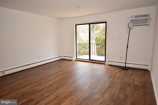 spare room featuring a wall unit AC, a baseboard heating unit, and wood finished floors