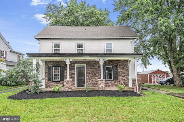 view of front of house with stone siding, a front yard, covered porch, and stucco siding