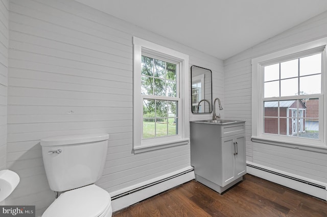 bathroom featuring a baseboard heating unit, toilet, wood finished floors, and vanity