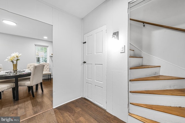 staircase with baseboard heating and wood finished floors