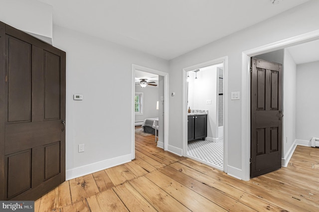 interior space featuring light wood-type flooring and baseboards