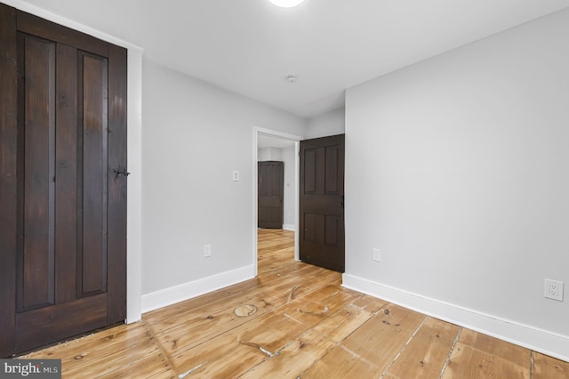 unfurnished bedroom featuring light wood finished floors and baseboards