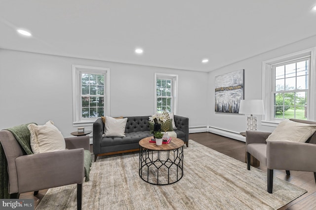 living area with baseboard heating, wood finished floors, a wealth of natural light, and recessed lighting