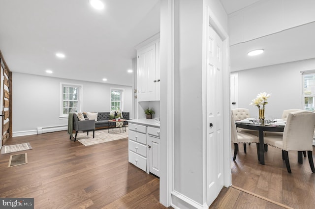 interior space with recessed lighting, dark wood-style flooring, visible vents, and baseboard heating