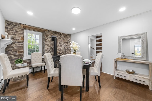 dining space with a wood stove, dark wood-style floors, stairs, and recessed lighting