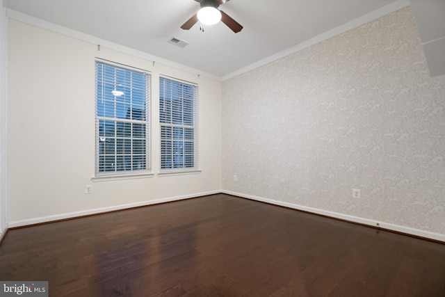 unfurnished room with wood finished floors, baseboards, visible vents, ceiling fan, and ornamental molding