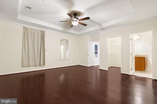 spare room featuring visible vents, ornamental molding, hardwood / wood-style floors, baseboards, and ceiling fan