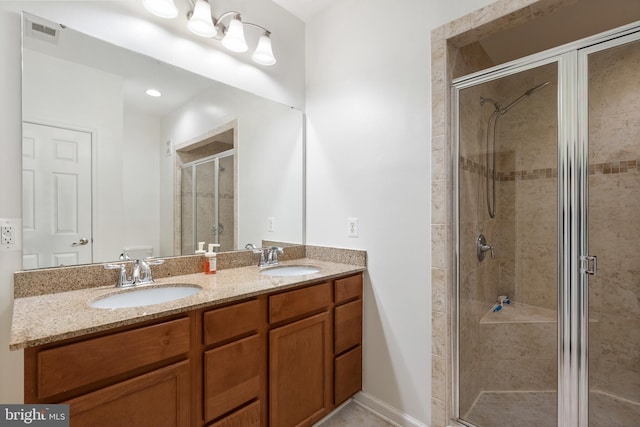 full bathroom with a sink, visible vents, double vanity, and a shower stall