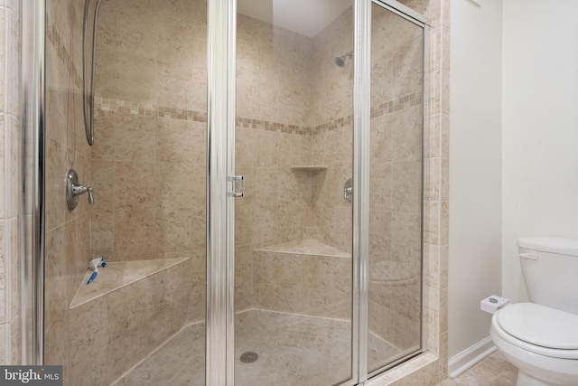 bathroom featuring a shower stall and toilet