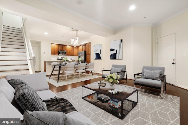 living area featuring recessed lighting, light wood-style flooring, crown molding, and stairs