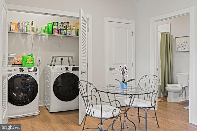 laundry area featuring wood finished floors, laundry area, and separate washer and dryer