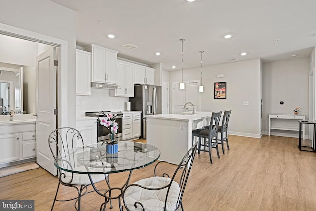 dining space featuring baseboards, light wood-type flooring, visible vents, and recessed lighting