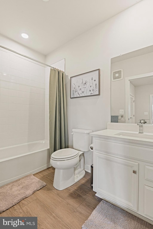 bathroom with toilet, shower / tub combo, wood finished floors, visible vents, and vanity