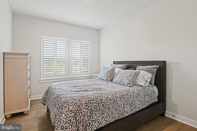 bedroom with baseboards and wood finished floors