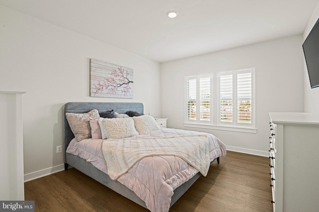 bedroom with baseboards and dark wood finished floors