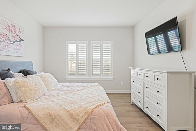 bedroom with dark wood finished floors and baseboards