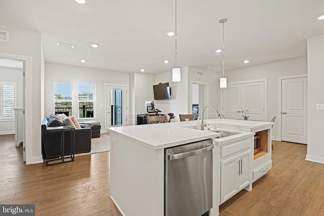 kitchen featuring a sink, light wood-type flooring, plenty of natural light, and stainless steel dishwasher