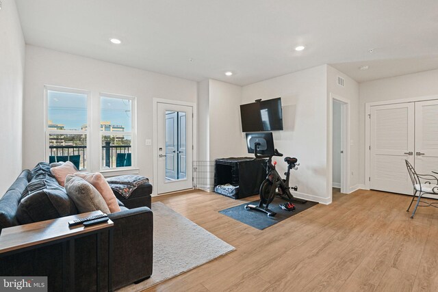 living area featuring visible vents, baseboards, light wood-style flooring, and recessed lighting