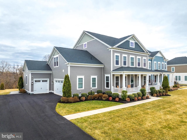 view of front of home featuring a shingled roof, aphalt driveway, an attached garage, covered porch, and a front yard