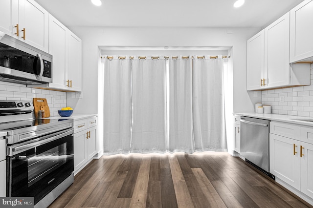 kitchen featuring white cabinets, appliances with stainless steel finishes, dark wood finished floors, and light countertops