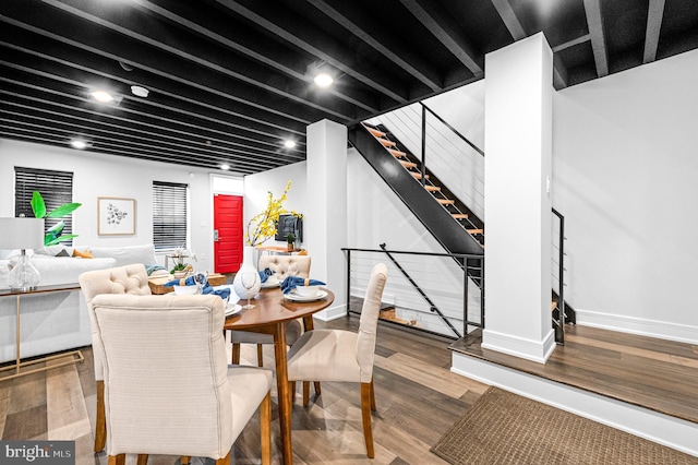 dining room featuring stairway, baseboards, and wood finished floors