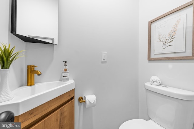 half bathroom featuring toilet and vanity