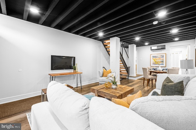 living area with baseboards, stairway, and wood finished floors