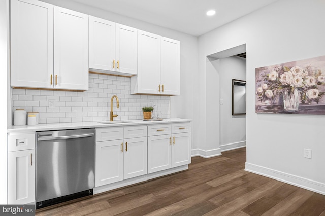 kitchen featuring dark wood-style flooring, light countertops, decorative backsplash, stainless steel dishwasher, and a sink