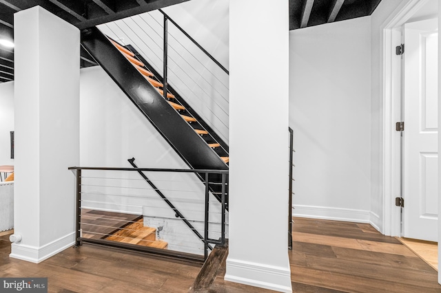 staircase featuring hardwood / wood-style flooring and baseboards