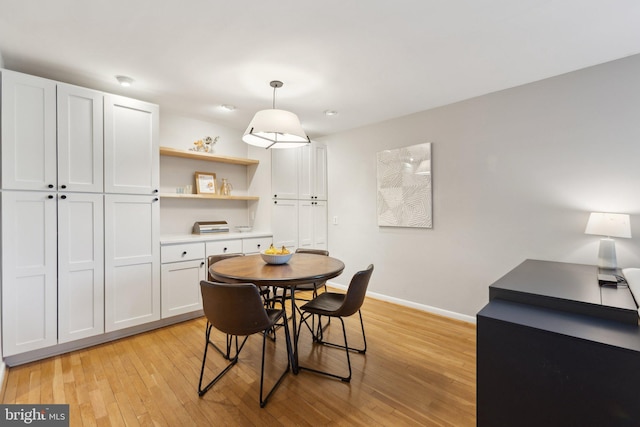 dining area with baseboards and light wood-style flooring