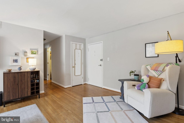 living area featuring light wood-style floors and baseboards