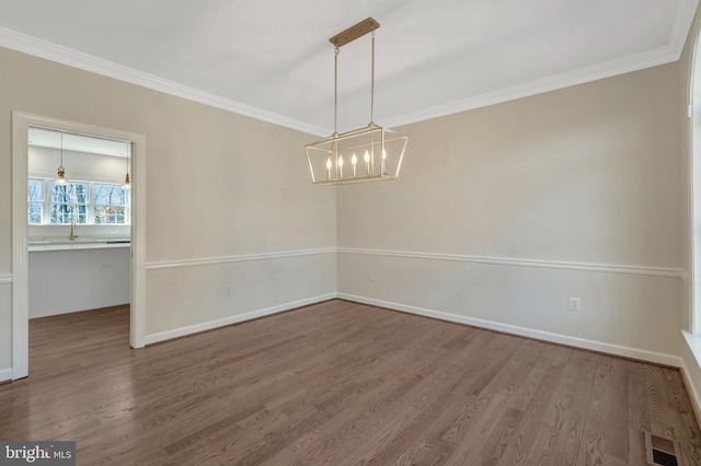 unfurnished dining area with ornamental molding, baseboards, and wood finished floors