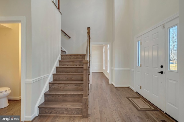 foyer featuring stairs, wood finished floors, and baseboards