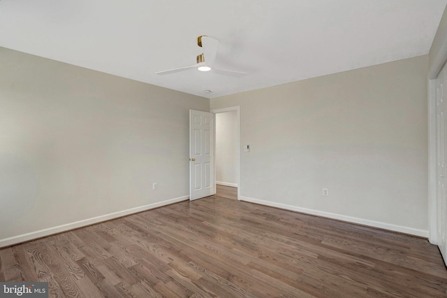 unfurnished room with ceiling fan, baseboards, and wood finished floors