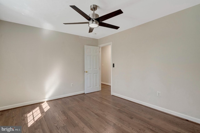 spare room featuring ceiling fan, wood finished floors, and baseboards