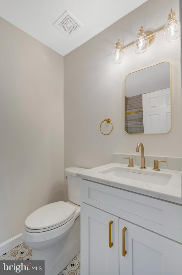 bathroom with visible vents, toilet, vanity, tile patterned flooring, and baseboards