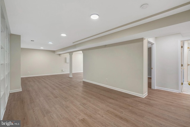 finished basement featuring light wood-style floors, recessed lighting, and baseboards