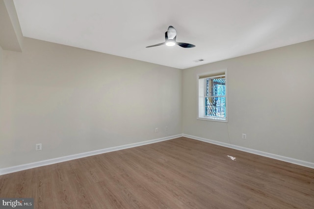 empty room with a ceiling fan, baseboards, and wood finished floors