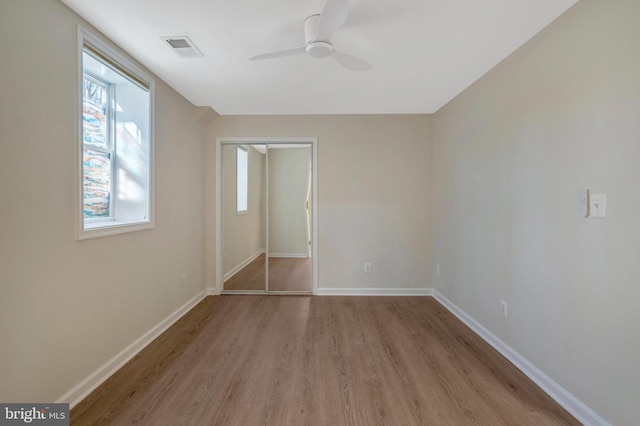 unfurnished bedroom with light wood-type flooring, baseboards, visible vents, and ceiling fan