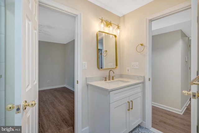 bathroom featuring wood finished floors, vanity, and baseboards