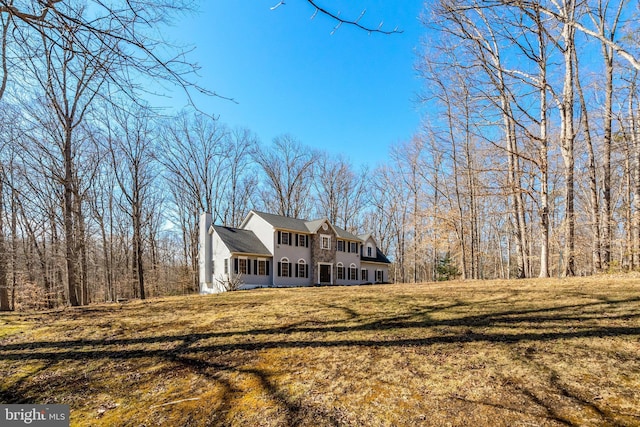 exterior space featuring a chimney and a yard