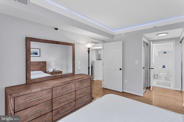 bedroom featuring visible vents, ornamental molding, ensuite bath, wood finished floors, and baseboards