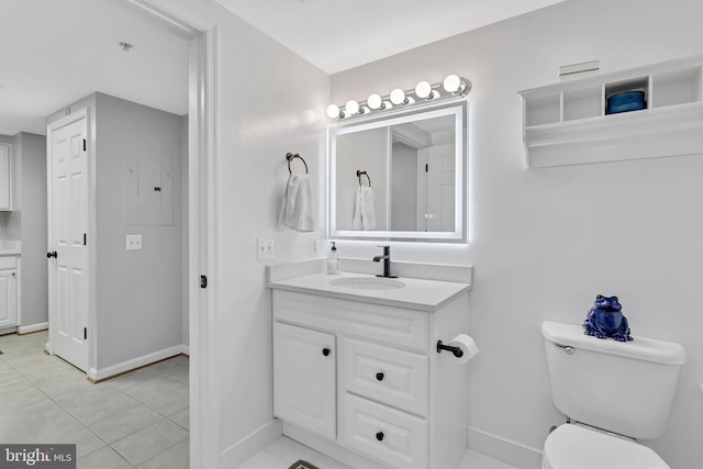 bathroom featuring toilet, tile patterned flooring, baseboards, and vanity