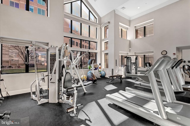 exercise room with ornamental molding, visible vents, and baseboards