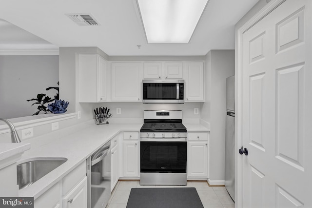 kitchen with light tile patterned floors, visible vents, stainless steel appliances, white cabinetry, and a sink