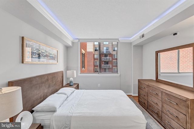 bedroom with baseboards, visible vents, and crown molding