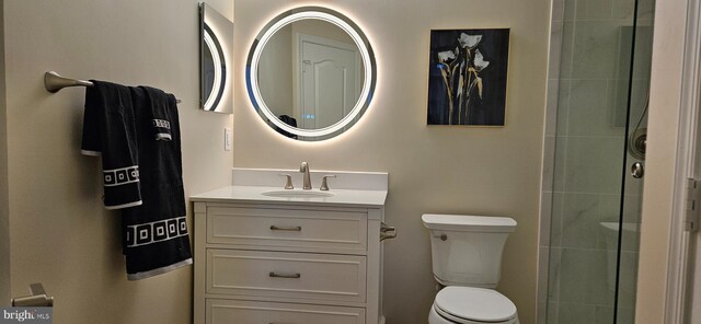 bathroom with vanity, toilet, and a tile shower