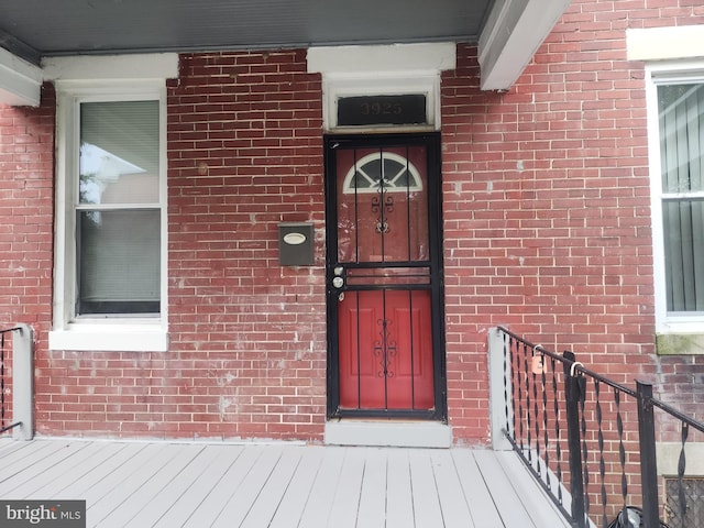 doorway to property featuring brick siding